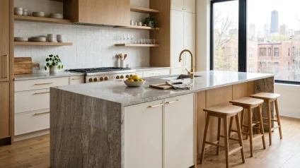 Granite waterfall island with polished gray and white veining in a Chicago kitchen with white oak cabinetry and brass fixtures